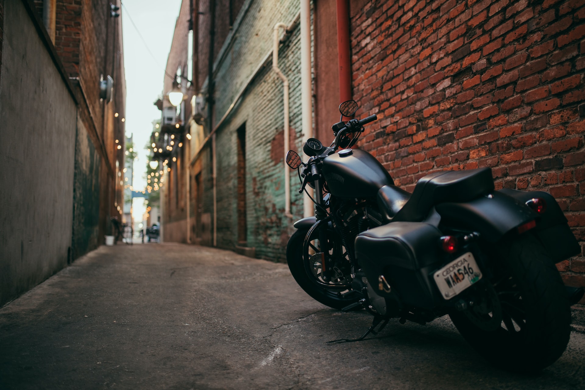 black cruiser motorcycle parked at the middle of the alley photo | Veteran Car Donations