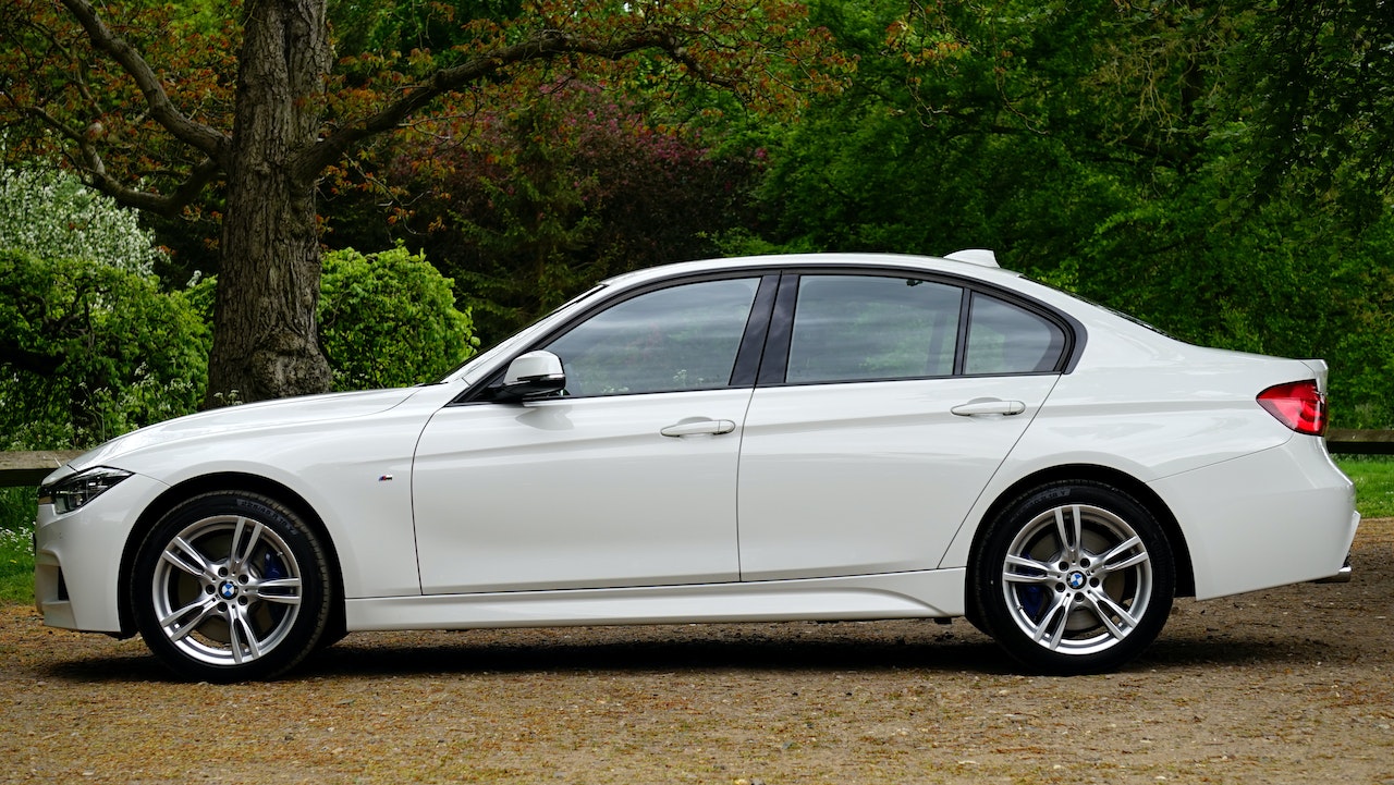 White Bmw Sedan Parked Beside Tree | Veteran Car Donations