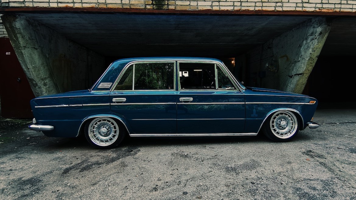 A Blue Vintage Car Parked Beside the Abandoned Building | Veteran Car Donations