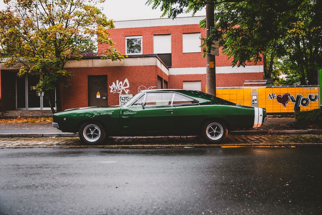 Green Coupe Parked on Gray Asphalt Road | Veteran Car Donations