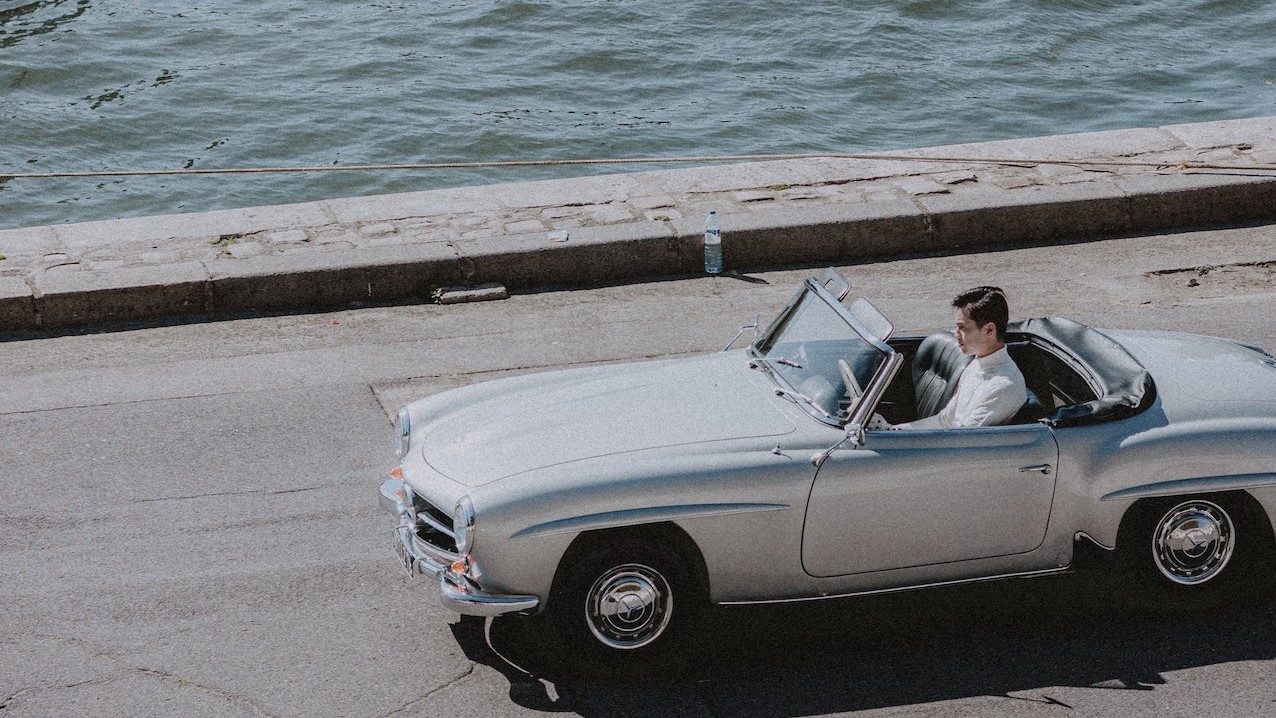 Man in white shirt travelling in silver car | Veteran Car Donations 