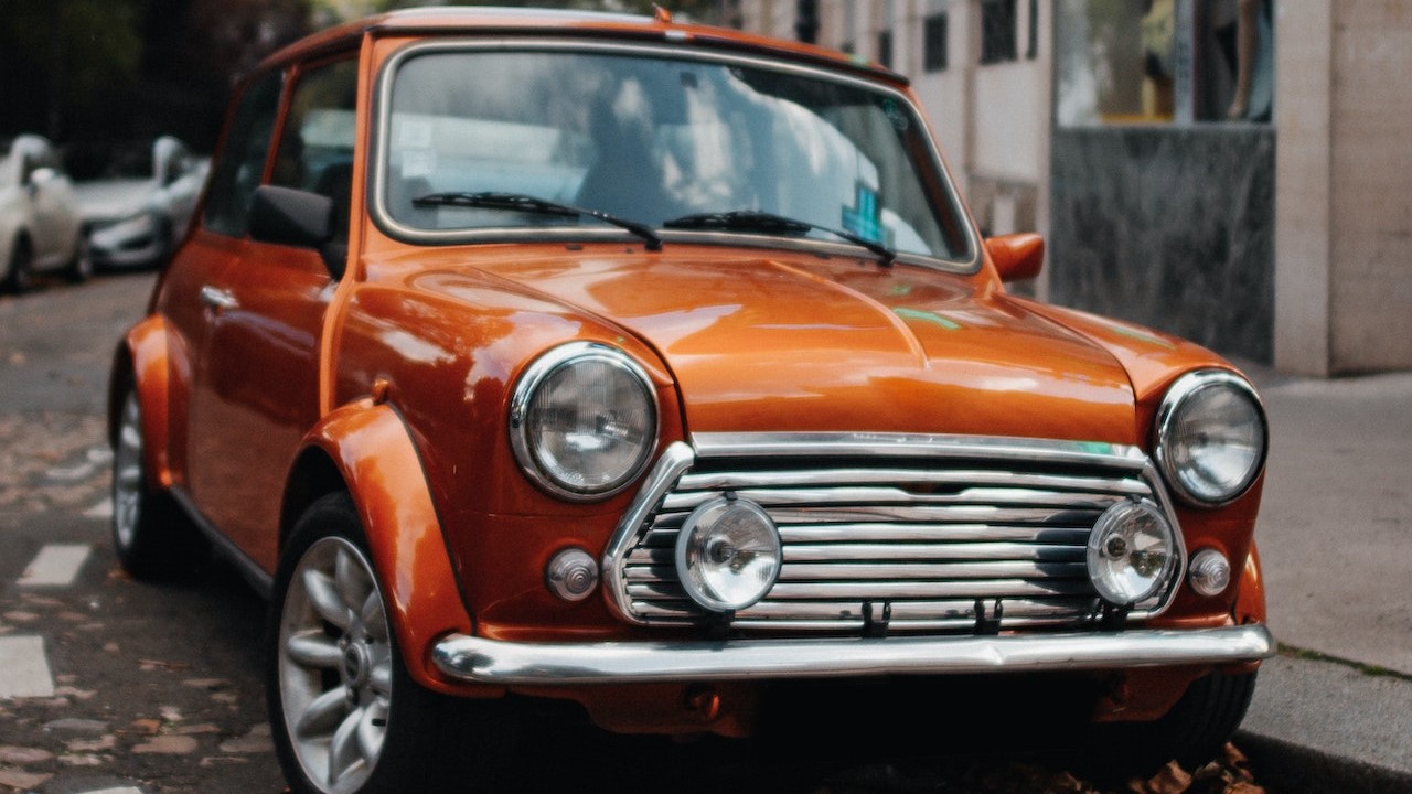 Orange Mini Copper Parked on Street | Veteran Car Donations