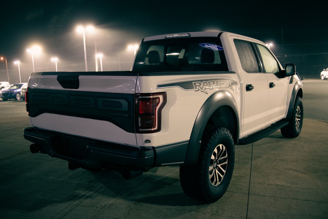 New pickup parked against cars at night | Veteran Car Donations