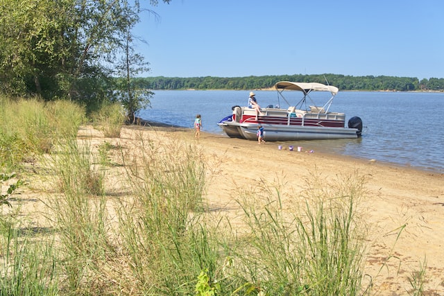 Pontoon Boat Docked on River with Children | Veteran Car Donations
