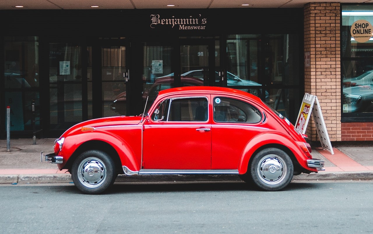 Red Oldtimer Car Parked at the Front of a store | Veteran Car Donations