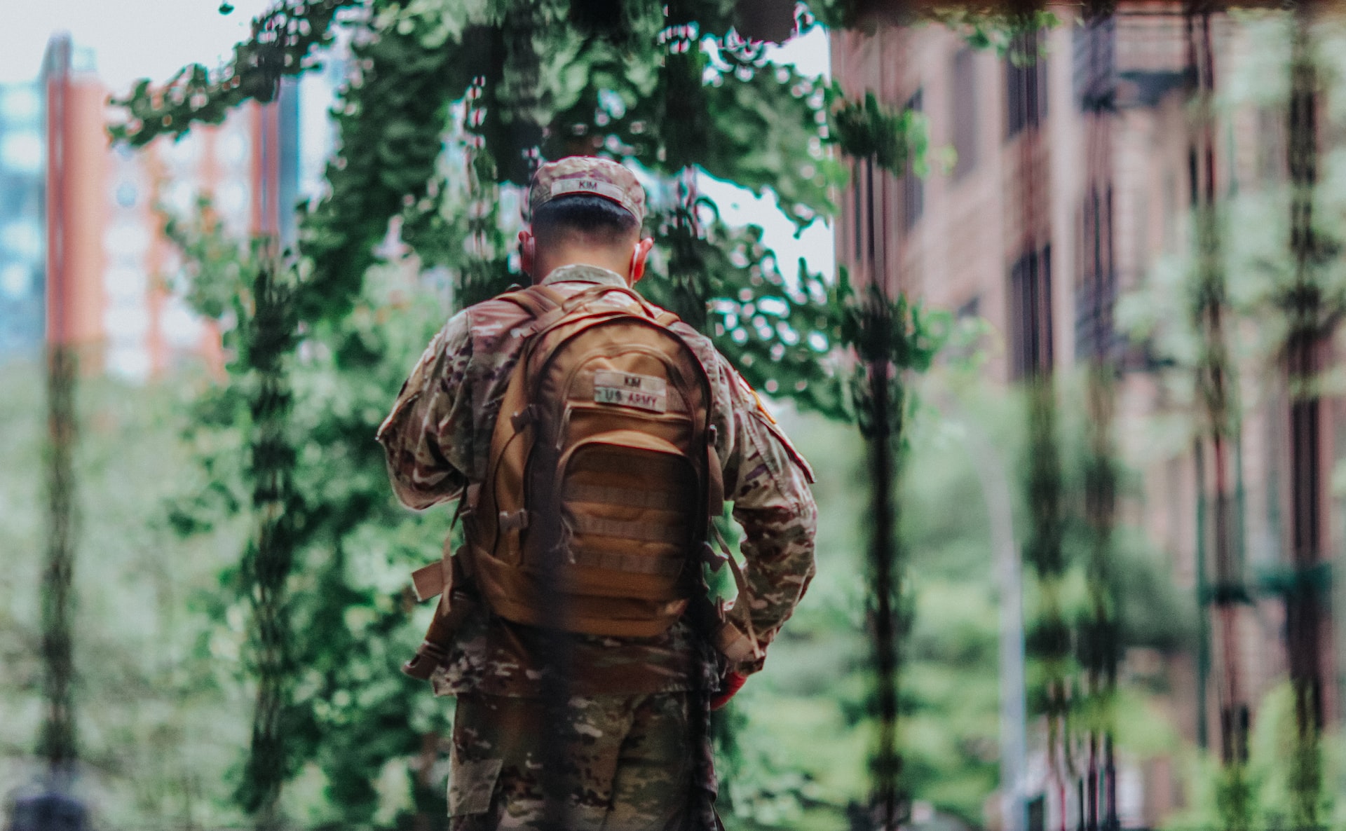 man in brown and black camouflage jacket standing forest during | Veteran Car Donations