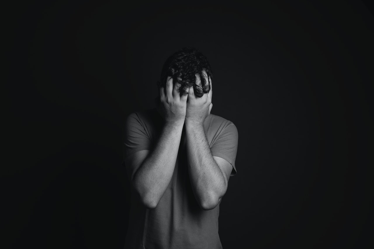 Gray scale Photo of Man Covering Face With His Hands | Veteran Car Donations
