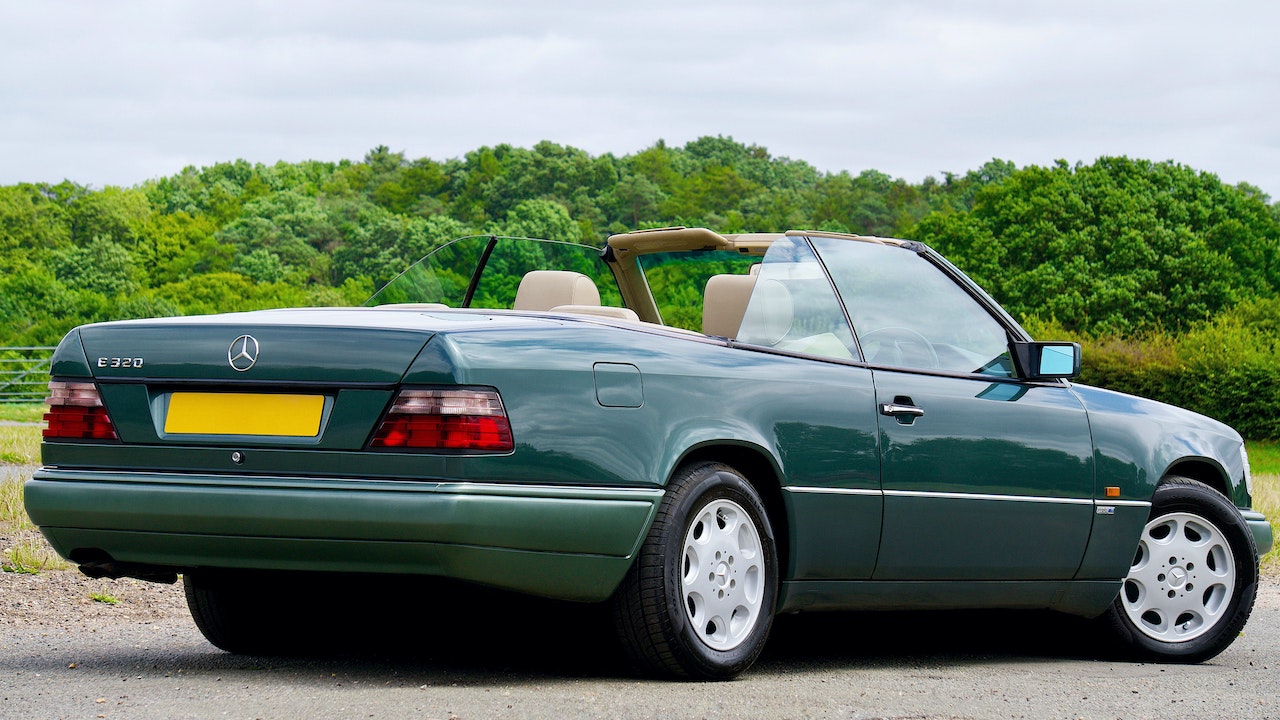 Green Car Parked on Concrete Pavement | Veteran Car Donations
