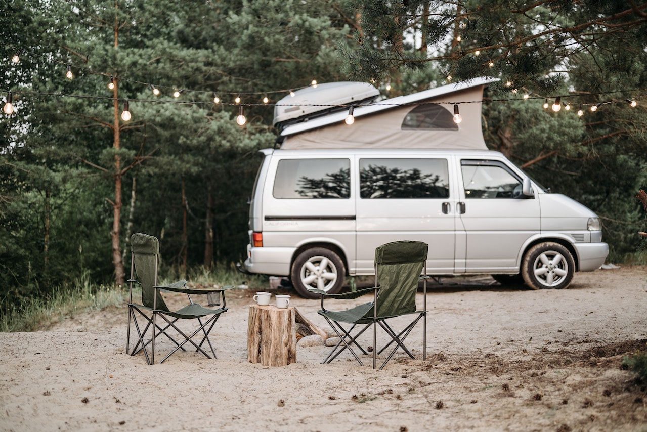 RV parked in a forest with lights | Veteran Car Donations