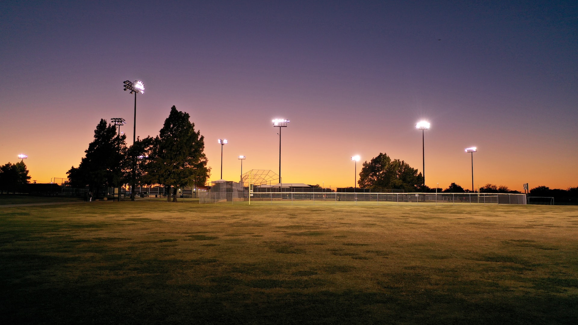 green grass field with trees and light posts | Veteran Car Donations