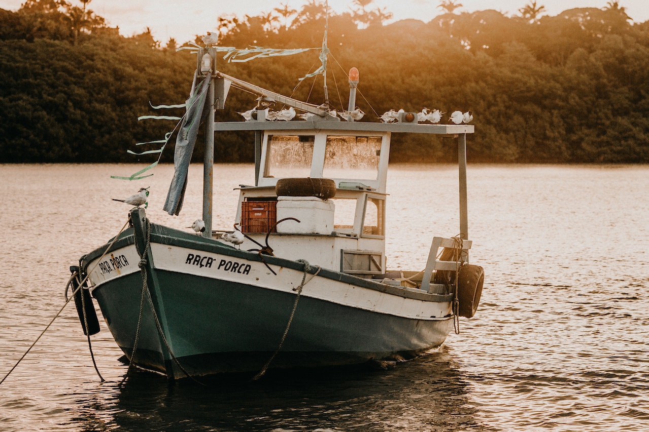 Fishing boat on rippled river in evening | Veteran Car Donations
