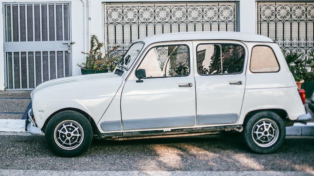 Retro car parked near asphalt sidewalk in front of building | Veteran Car Donations