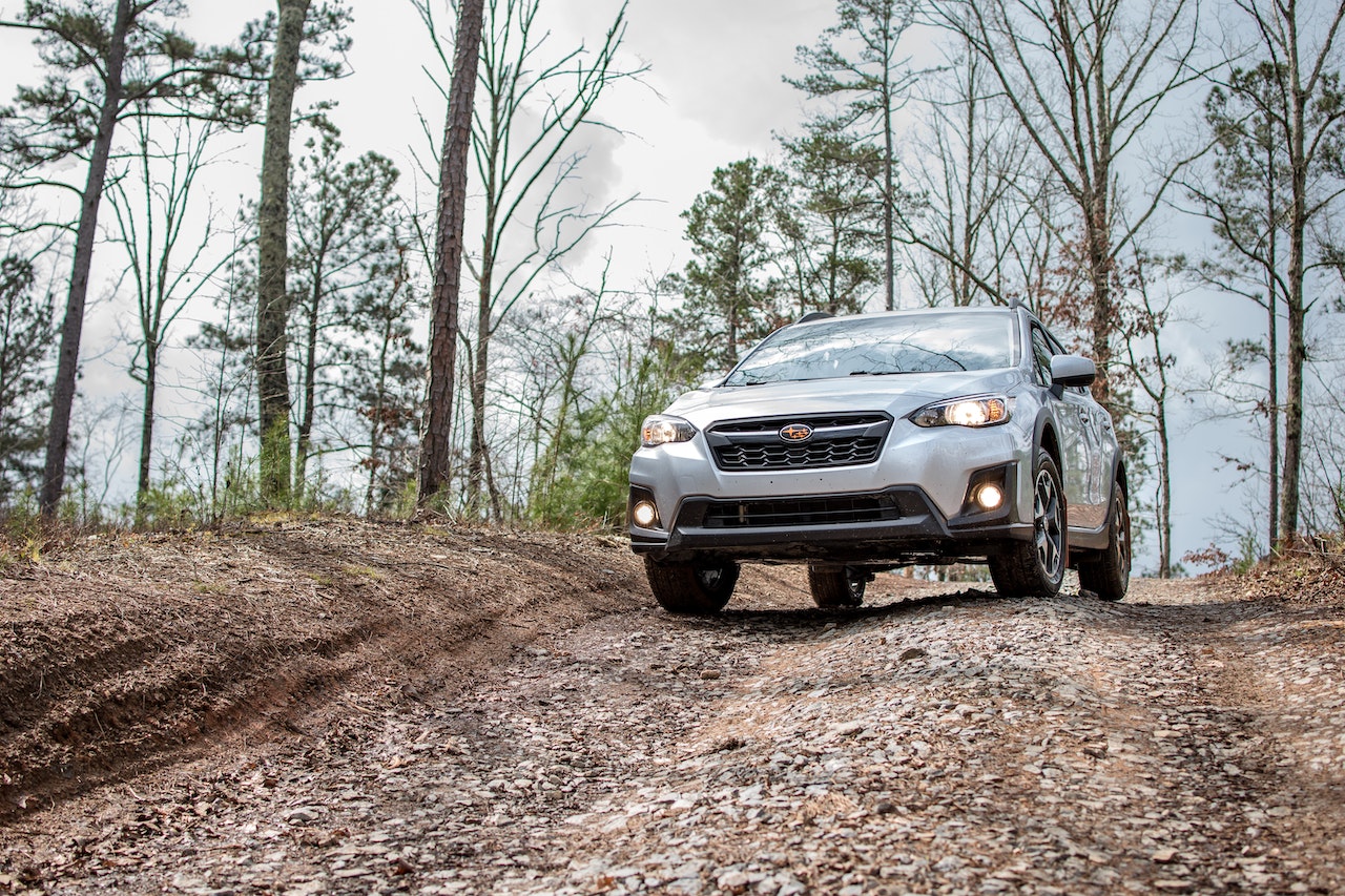 Silver Car Driving on Dirt and Rocky Road | Veteran Car Donations