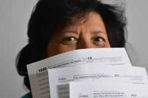 Woman Holding Tax Forms - VeteranCarDonations.org