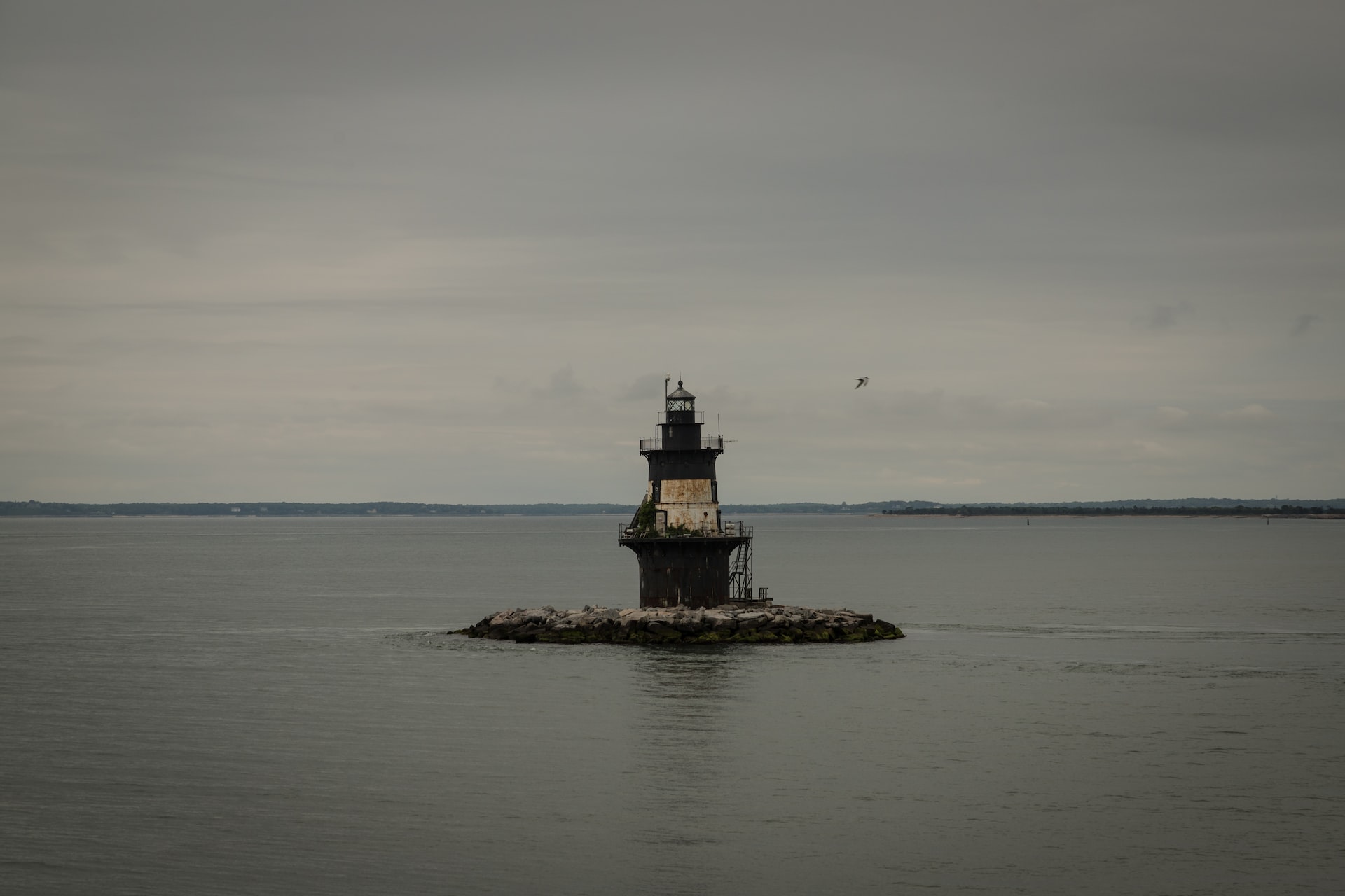 A lighthouse sitting the middle of a body of water | Veteran Car Donations