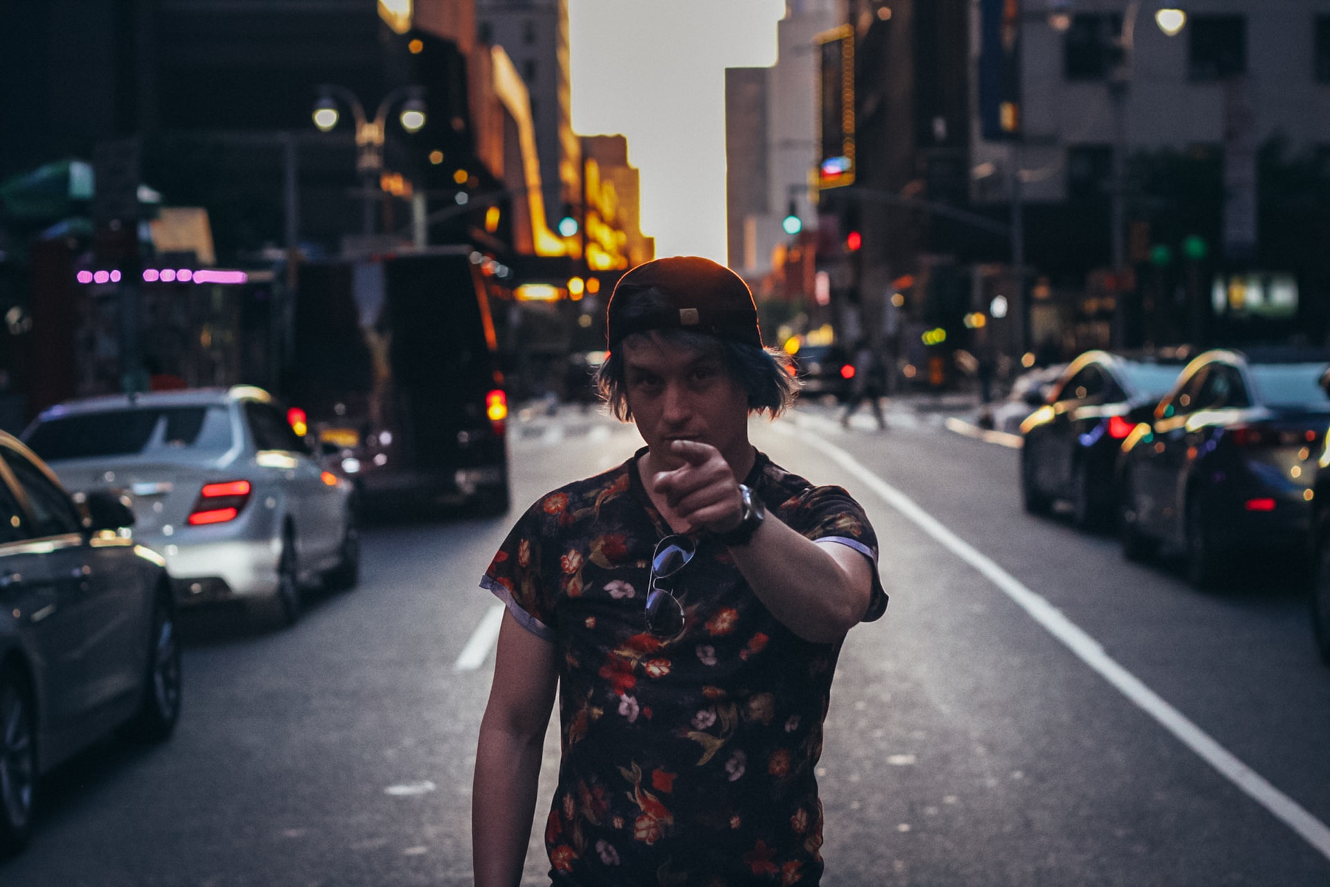 man in black and white floral shirt standing on sidewalk during night time | Veteran Car Donations