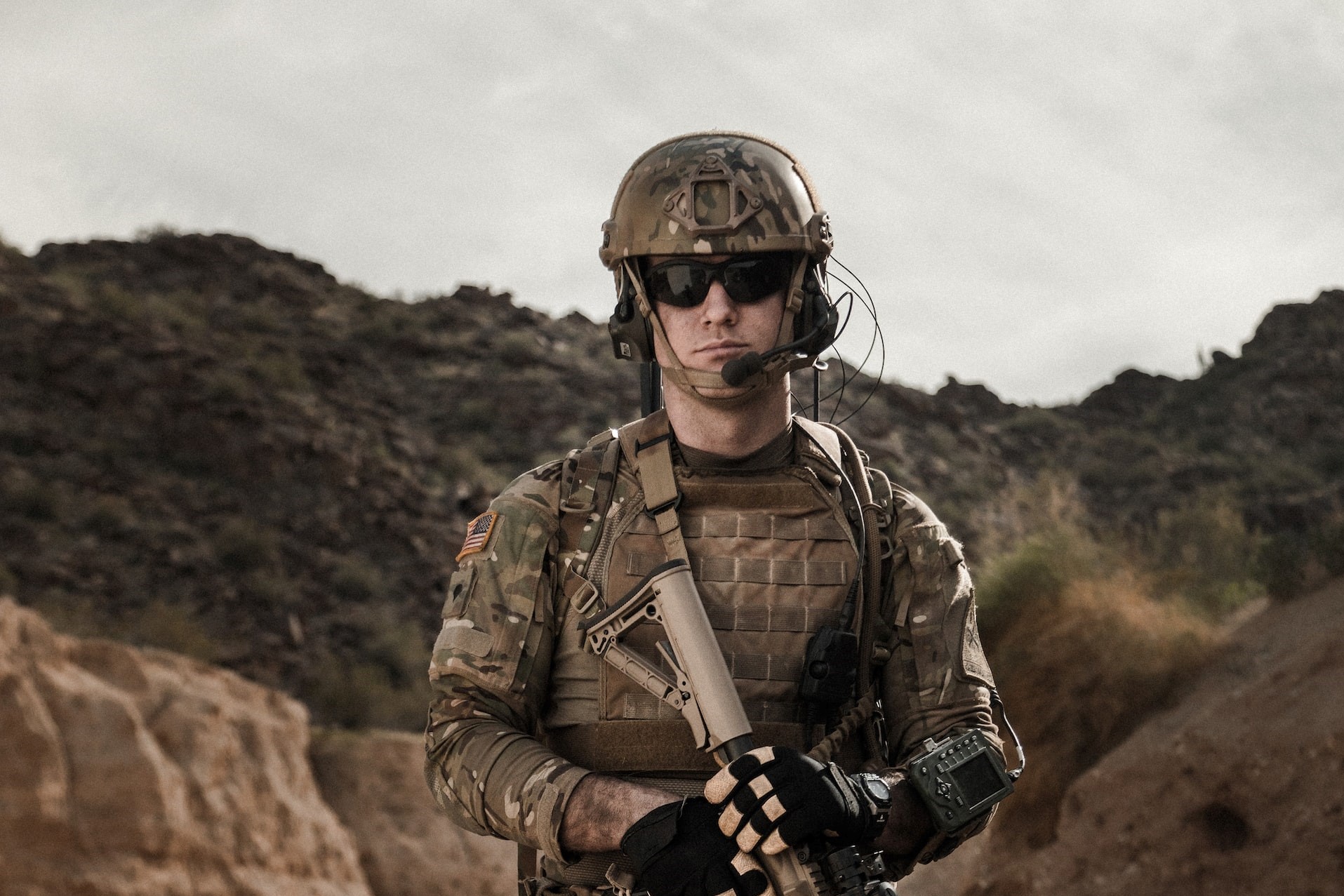 Man in brown and black camouflage uniform holding rifle | Veteran Car Donations