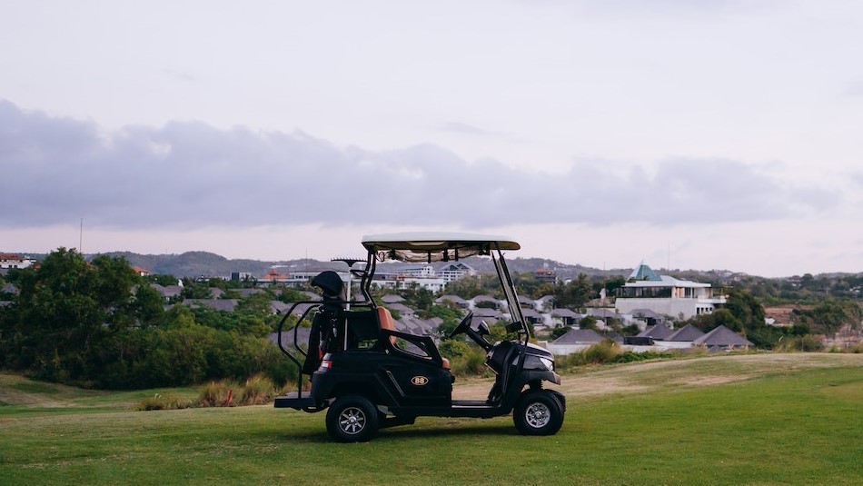 Black Golf Cart on Green Grass Field Under White Clouds | Veteran Car Donations