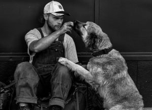 A Homeless Veteran Feeding His Dog - VeteranCarDonations.org