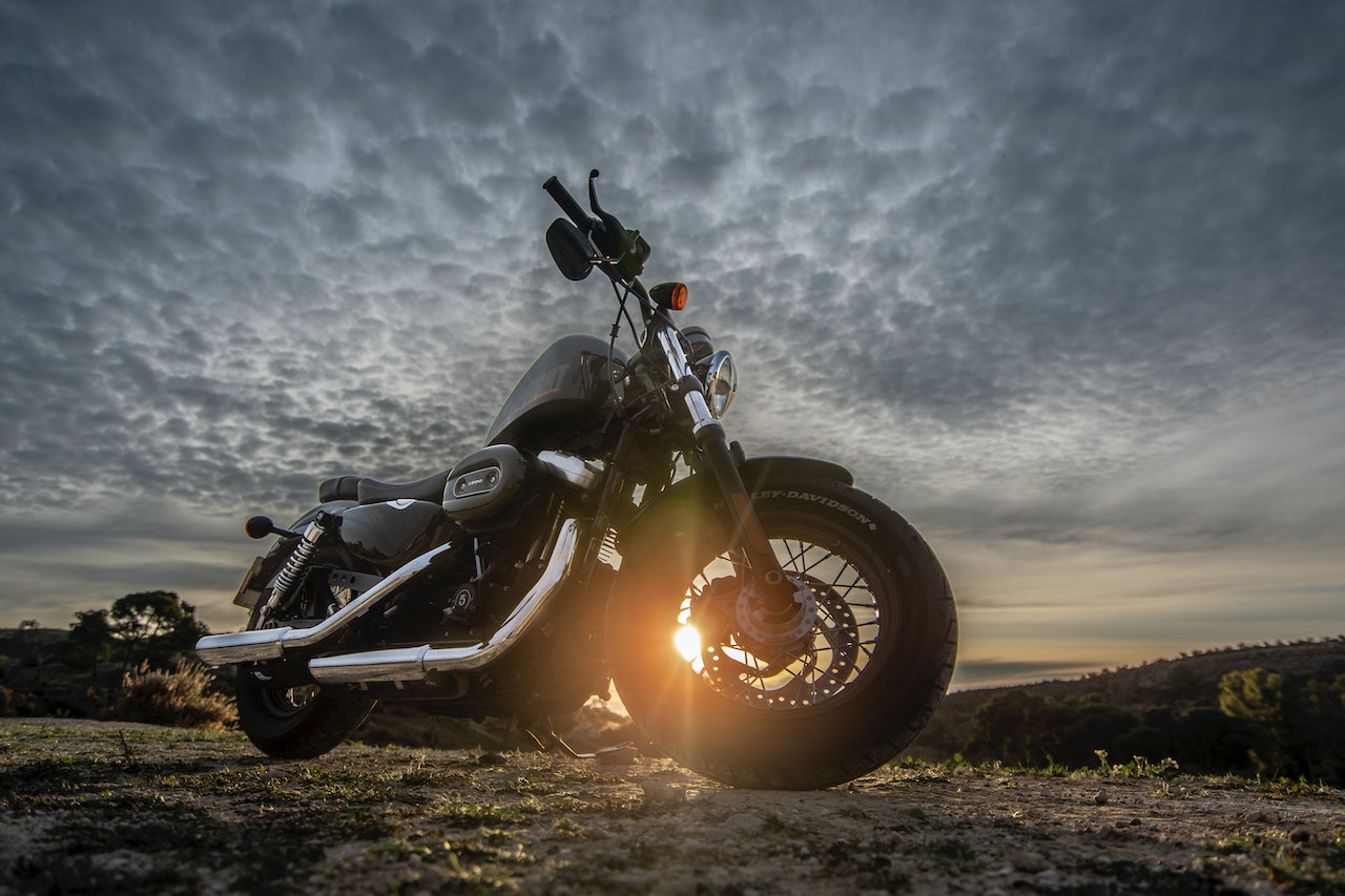 Low Angle Photo of Black Harley Davidson Forty-Eight 1200 Motorcycle Parked on Dirt Road During Golden Hour | Veteran Car Donations