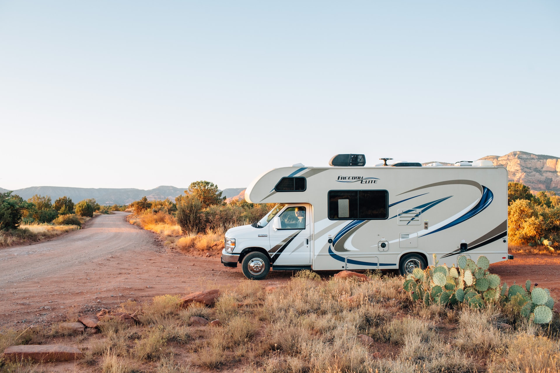 Man Driving White Rv on a Dirt Road | Veteran Car Donations