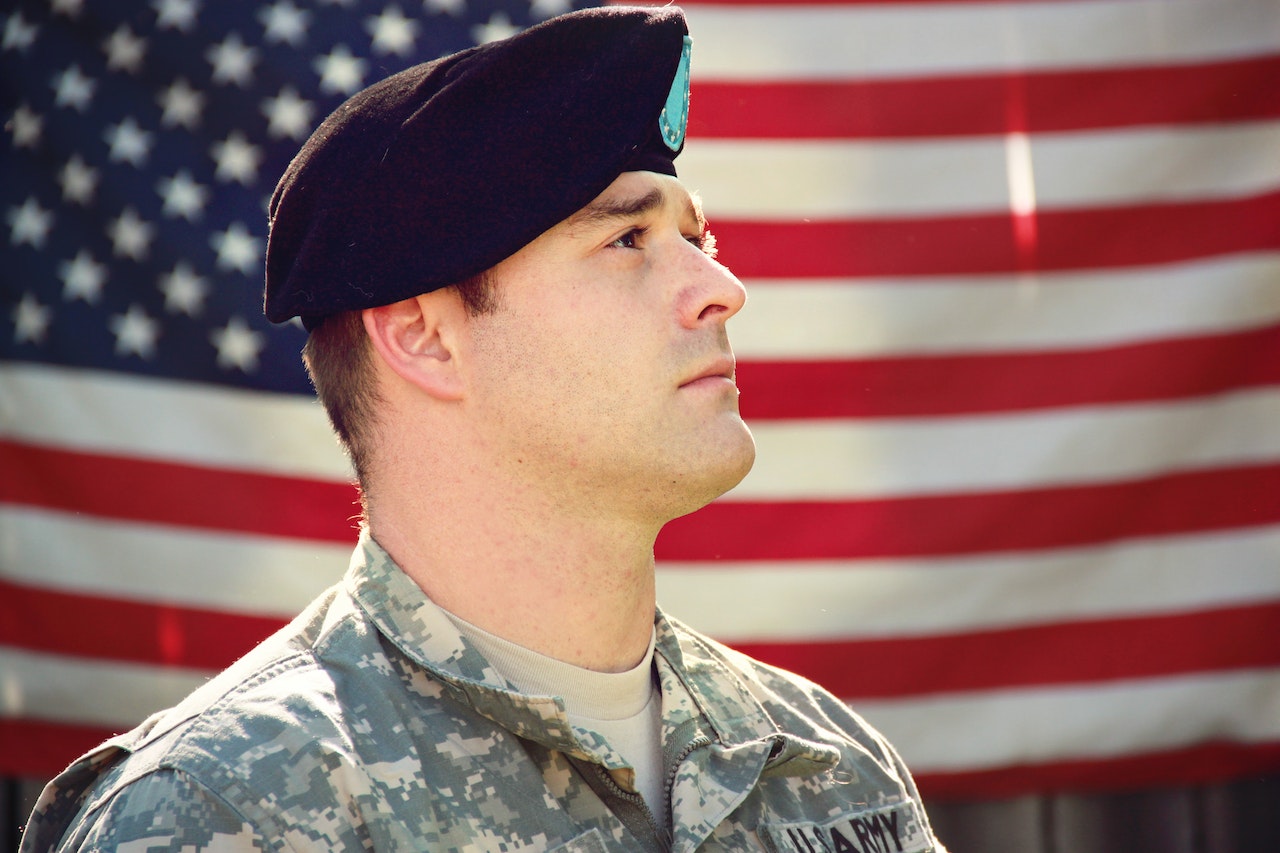 Man Wearing Combat Hat And Top Looking Up Near Flag Of America | Veteran Car Donations