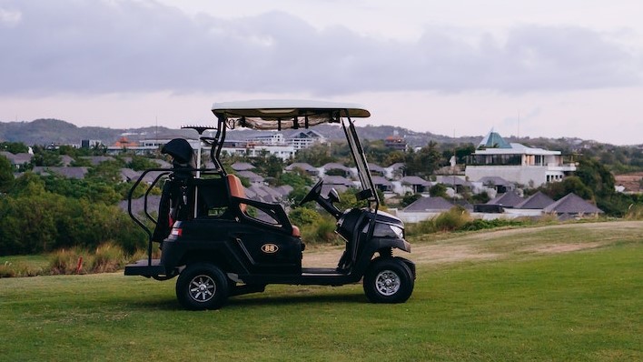 Black Golf Cart on Green Grass Field Under White Clouds | Veteran Car Donations