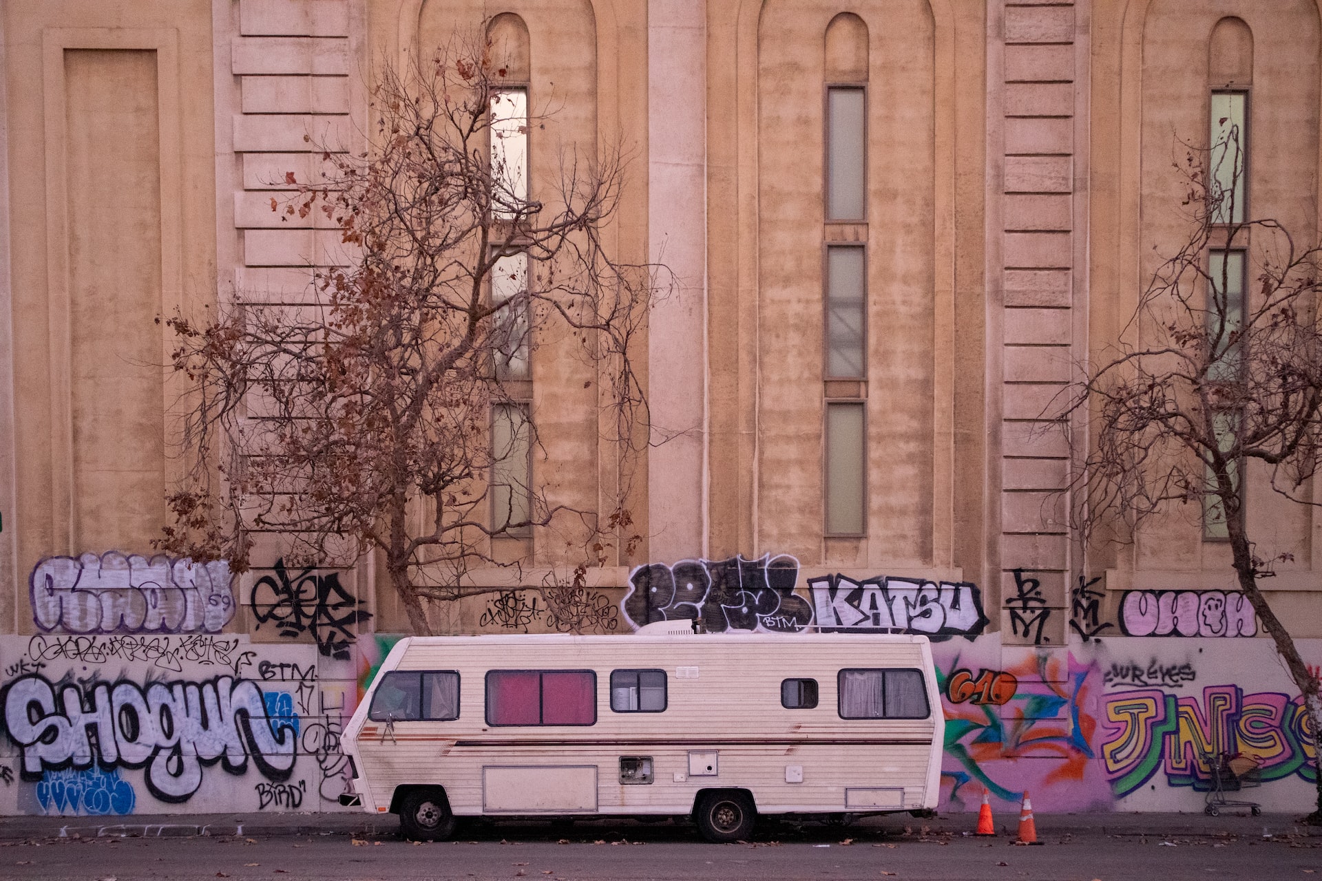 Biege Rv Parked Near Wall full of Graffiti | Veteran Car Donations