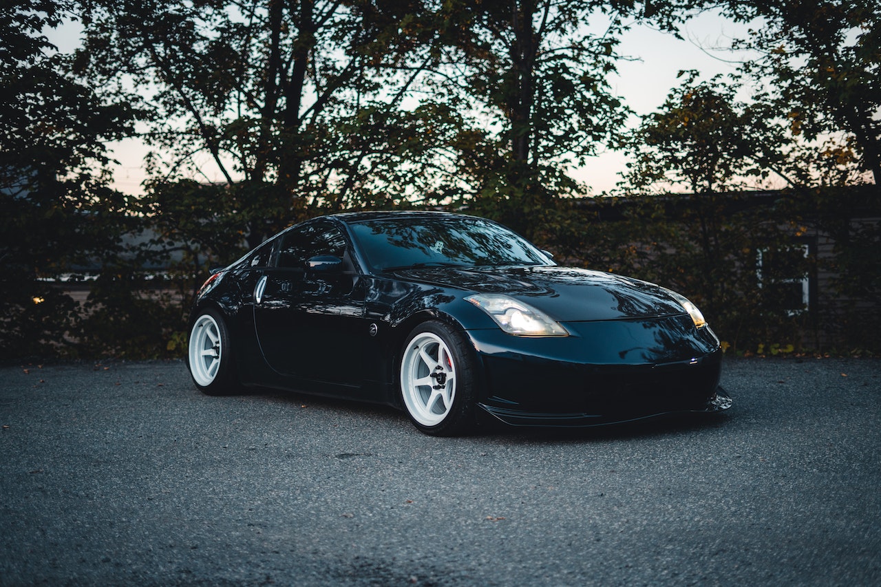 Black Car with White Wheels Parked on Asphalt Road | Veteran Car Donations