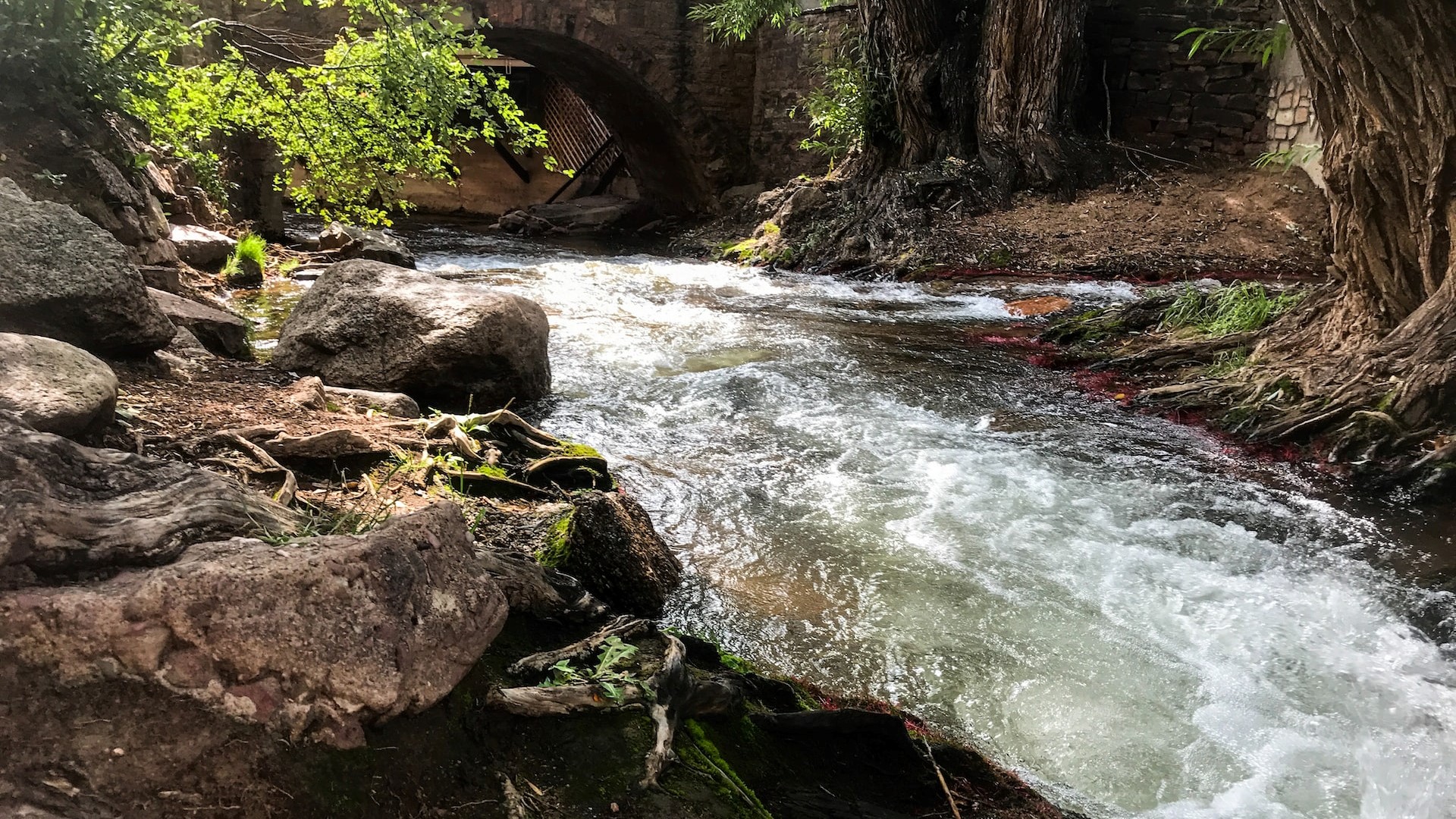 Flowing stream under a bridge | Veteran Car Donations