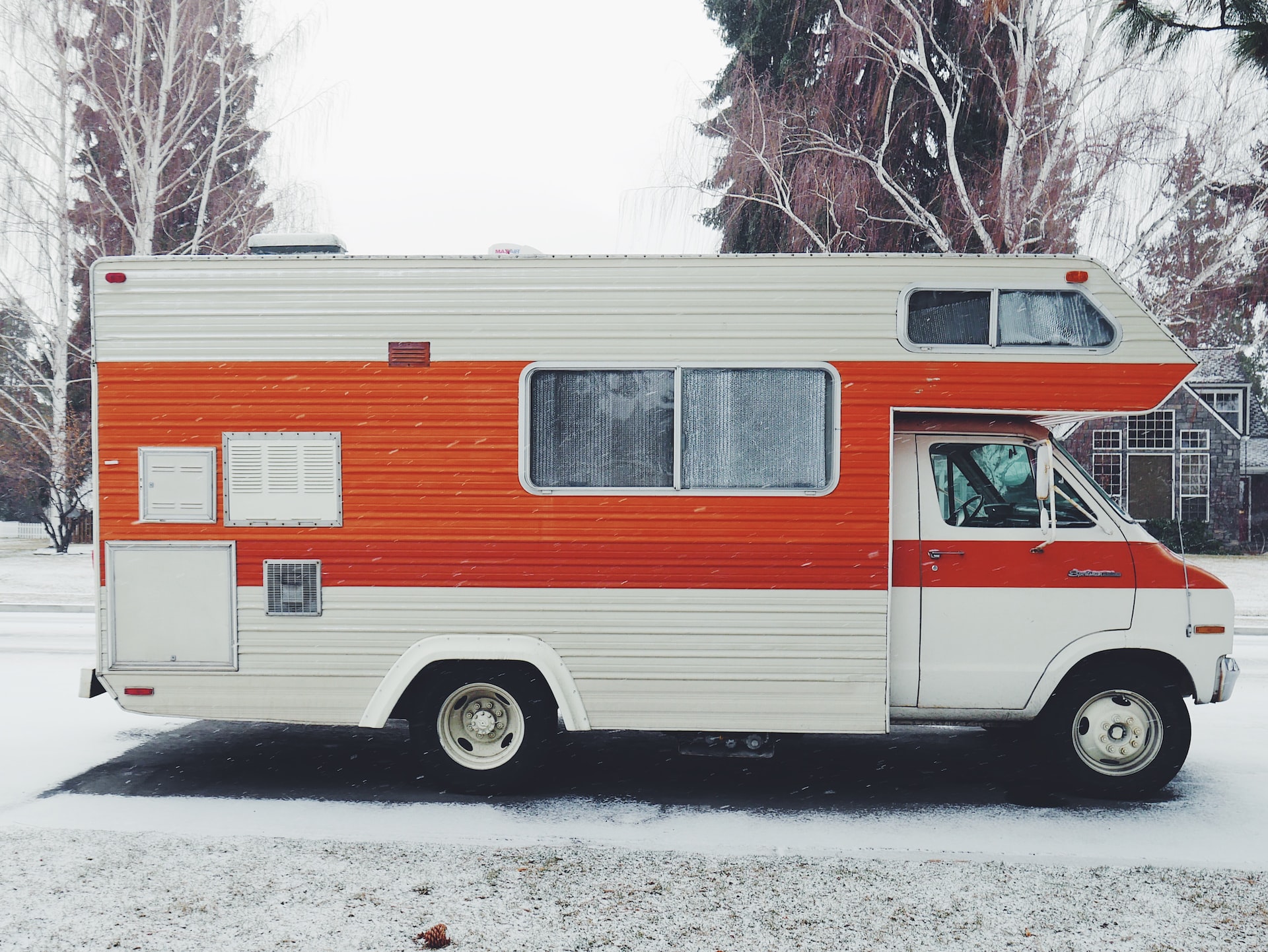 Orange and White Motorhome in a snowy road | Veteran Car Donations