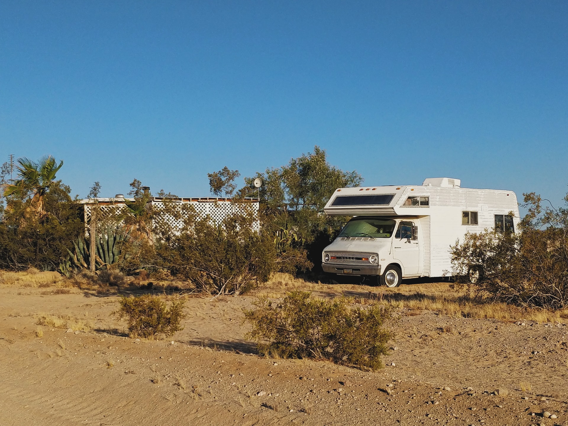 White Rv Parked Near Green Plants | Veteran Car Donations
