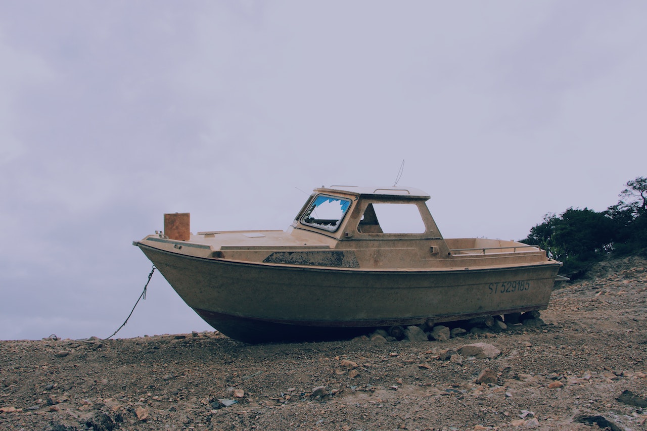 Brown Boat on Ground | Veteran Car Donations
