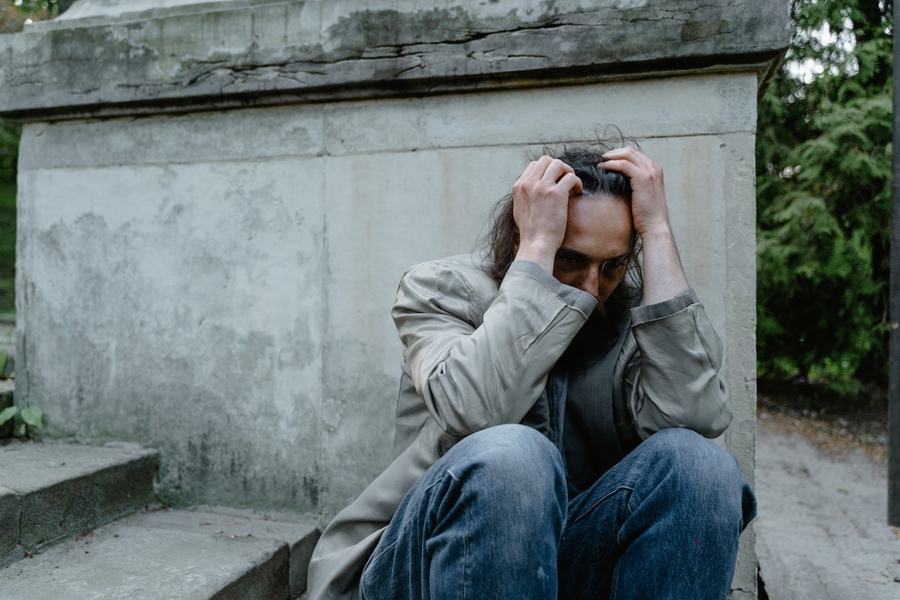 Worried Mad Sitting on a Concrete Stairs | Veteran Car Donations
