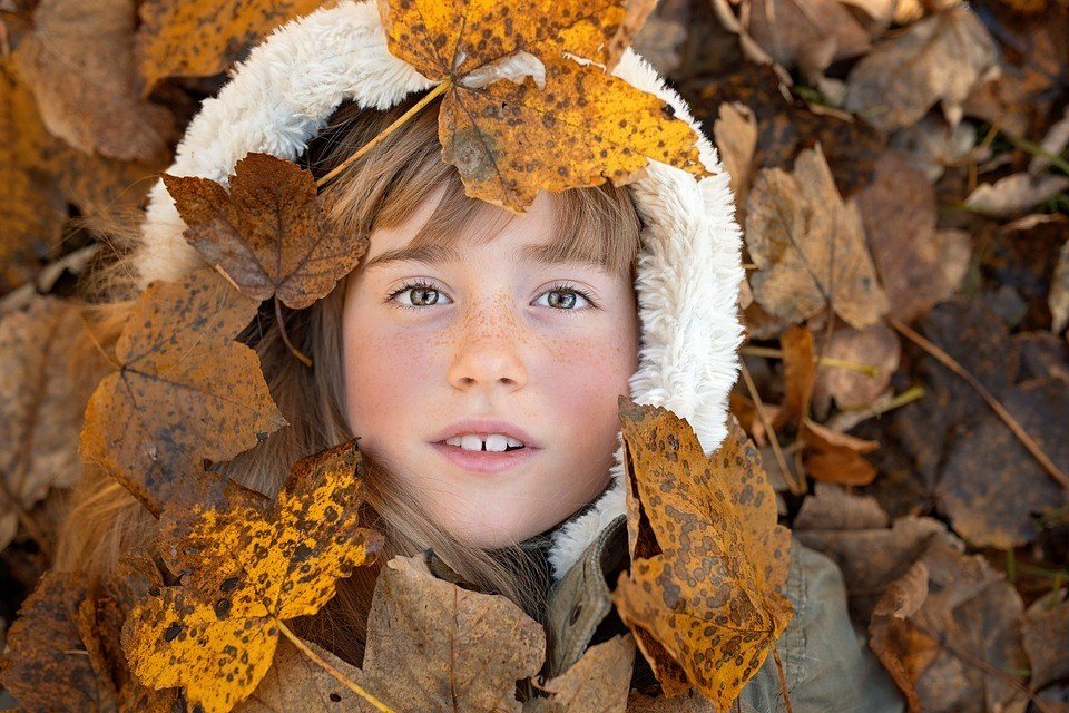 Kid Laying on an Autumn Foliage - VeteranCarDonations.org