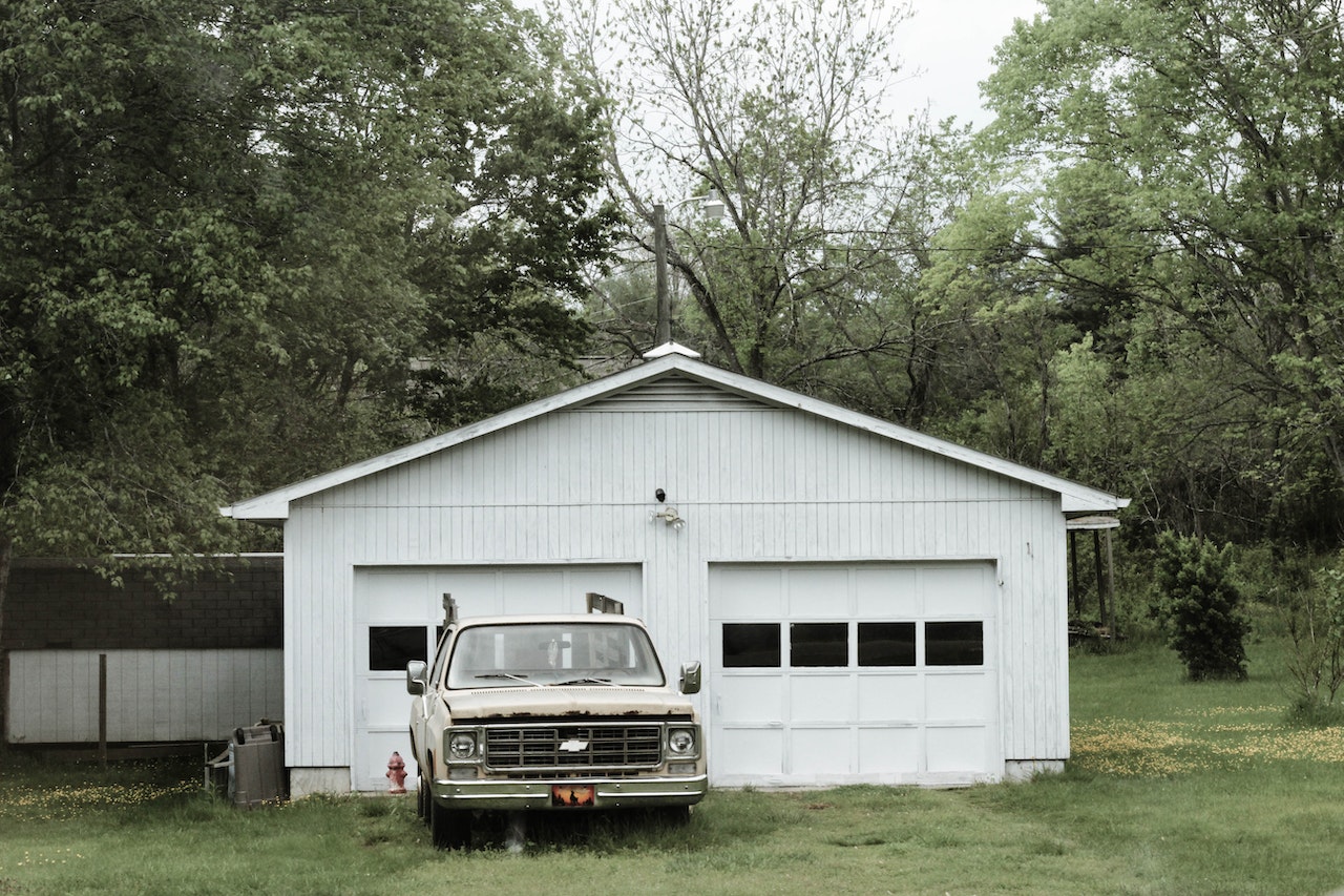Classic White Chevrolet Pickup Truck Near White 2-door Garage Near Trees | Veteran Car Donations