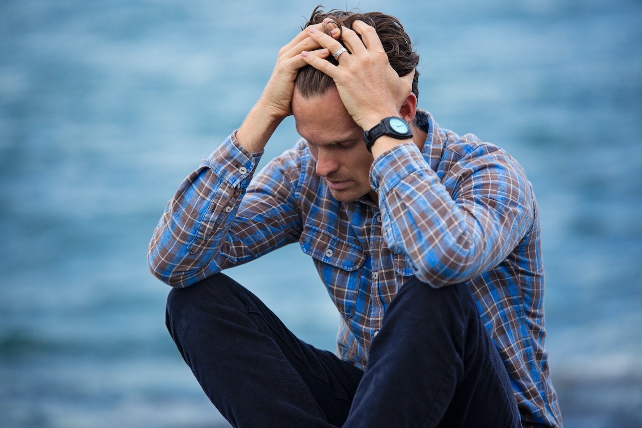 Man in Blue and Brown Plaid Dress Shirt Touching His Hair | Veteran Car Donations
