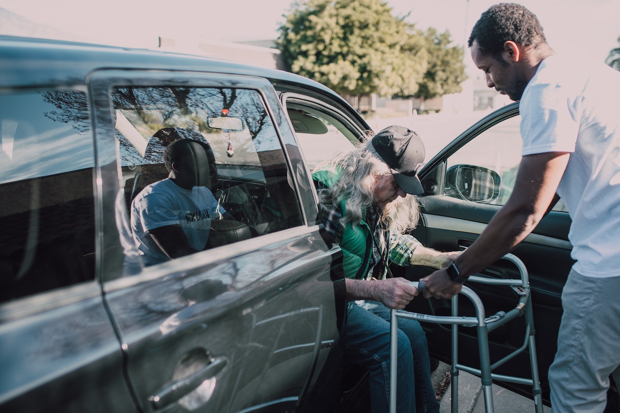 Man in White Shirt Helping an Elderly Person | Veteran Car Donations