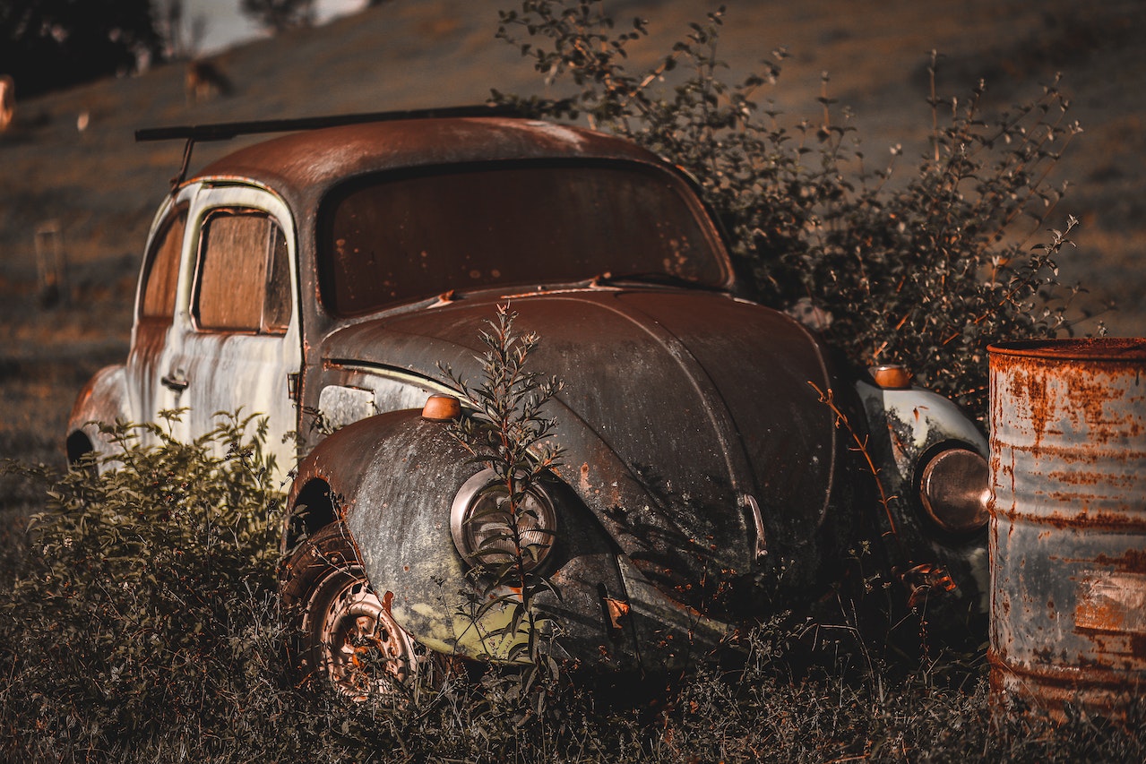 Photo of Abandoned Vintage Volkswagen Beetle Near Rusty Drum | Veteran Car Donations
