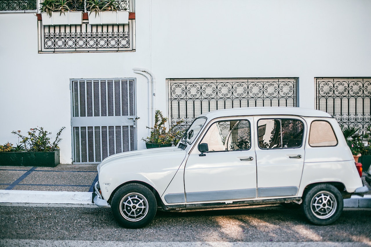 Retro car parked near asphalt sidewalk in front of building | Veteran Car Donations
