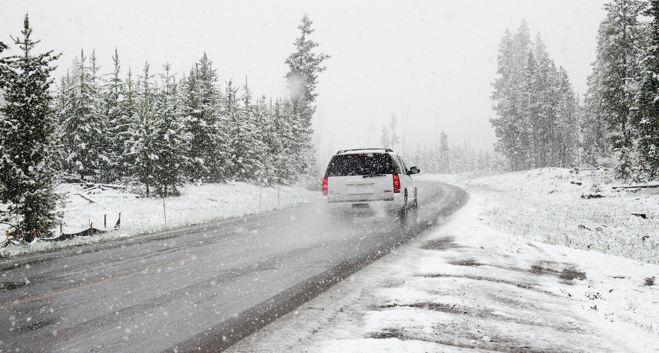 White SUV on Road Near Snow Covered Trees | Veteran Car Donations
