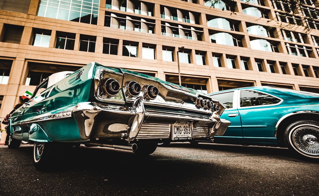 Green Vintage Car Parked Beside Brown Building | Veteran Car Donations
