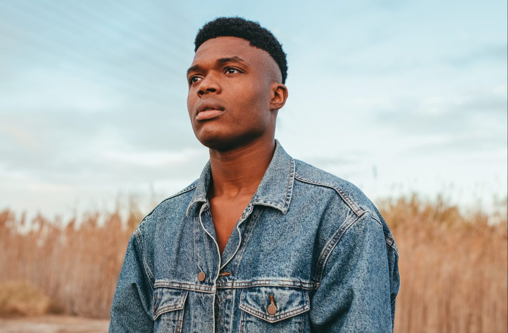 man in blue denim jacket standing on brown field during daytime | Veteran Car Donations