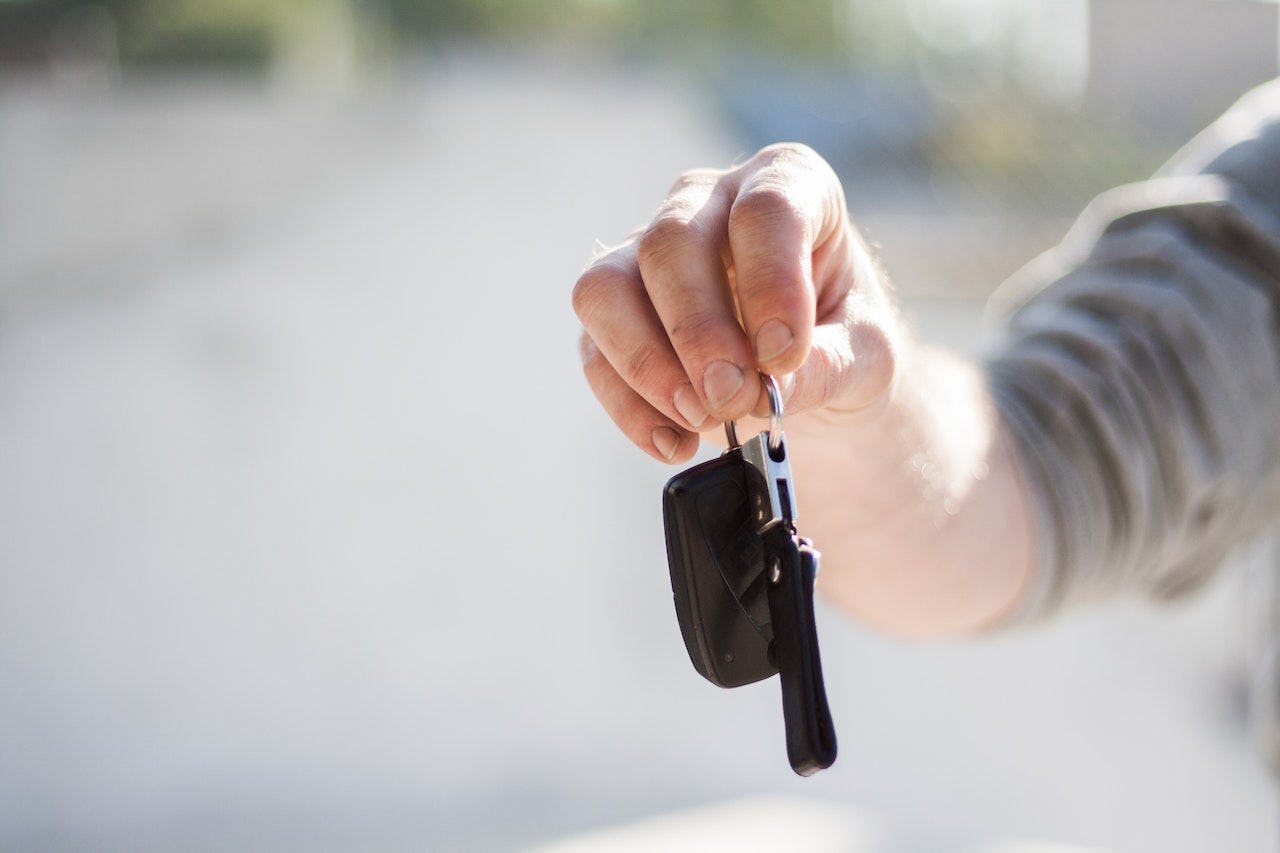 Person in Grey Shirt Handing Keys | Veteran Car Donations