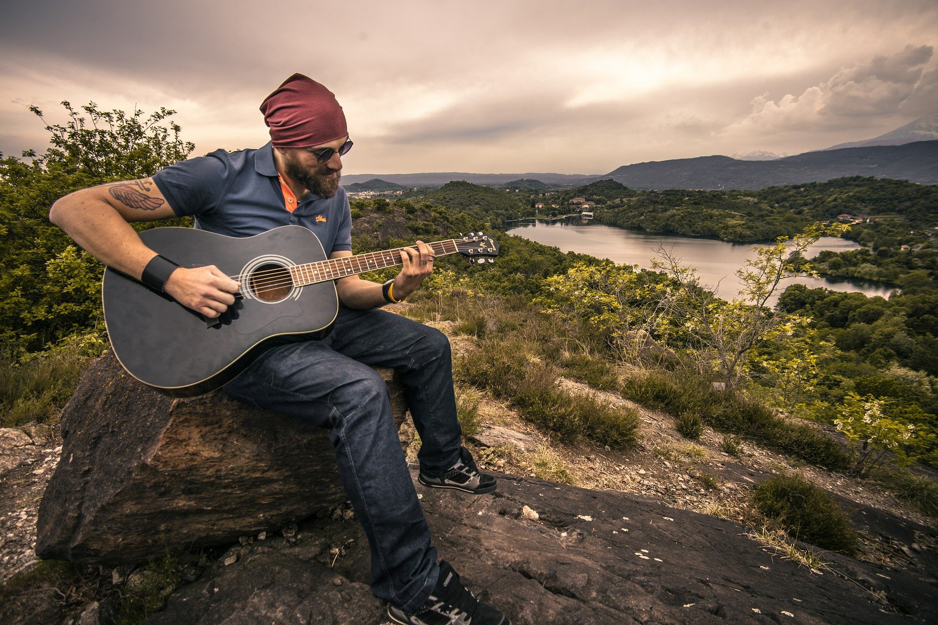 Guitarist playing outdoors | Veteran Car Donations