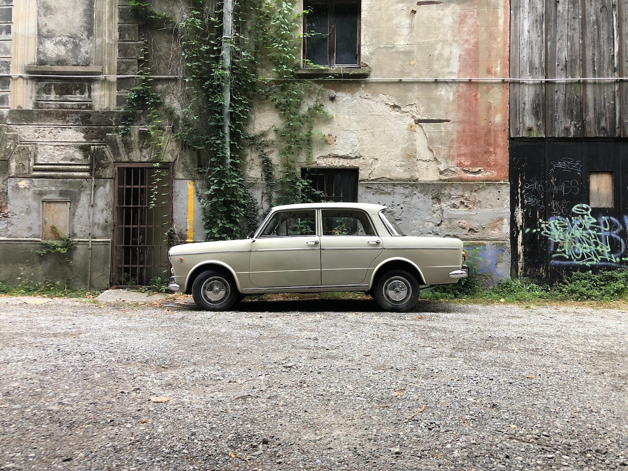 Vintage Car Parked Beside an Old Concrete Building | Veteran Car Donations