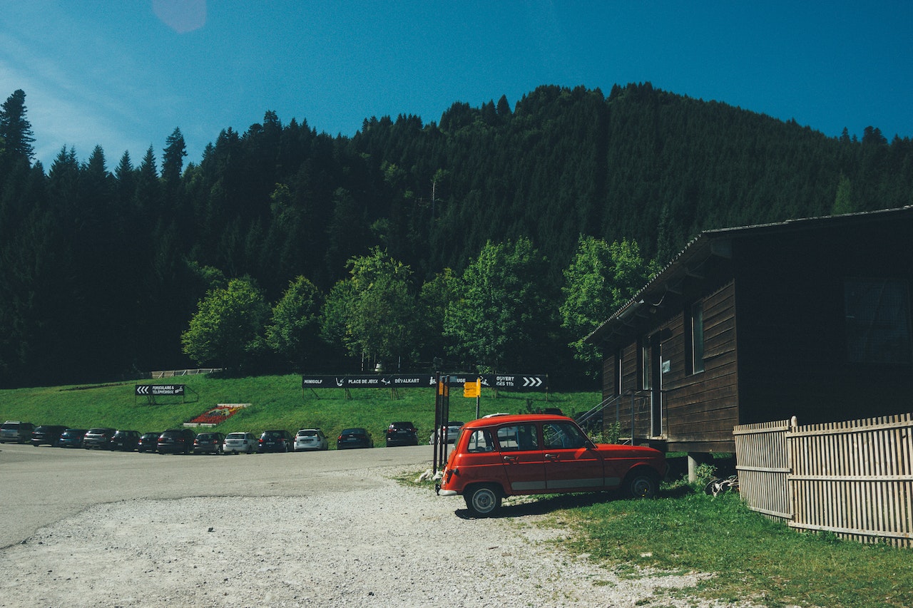 Red 5-door Hatchback Near the Brown Wooden House in Daytime | Veteran Car Donations
