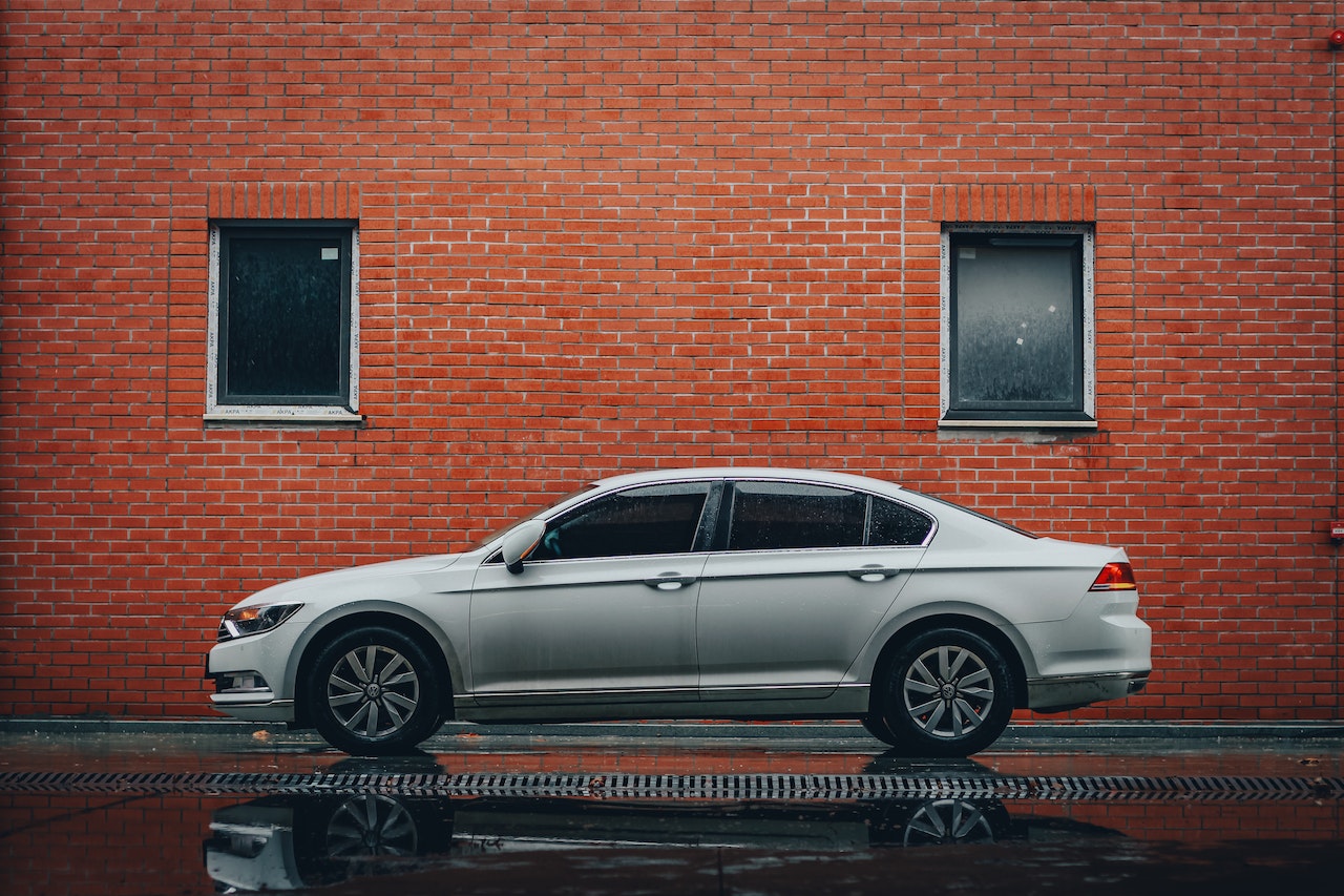 Silver Sedan Parked Beside Brown Brick Wall | Veteran Car Donations