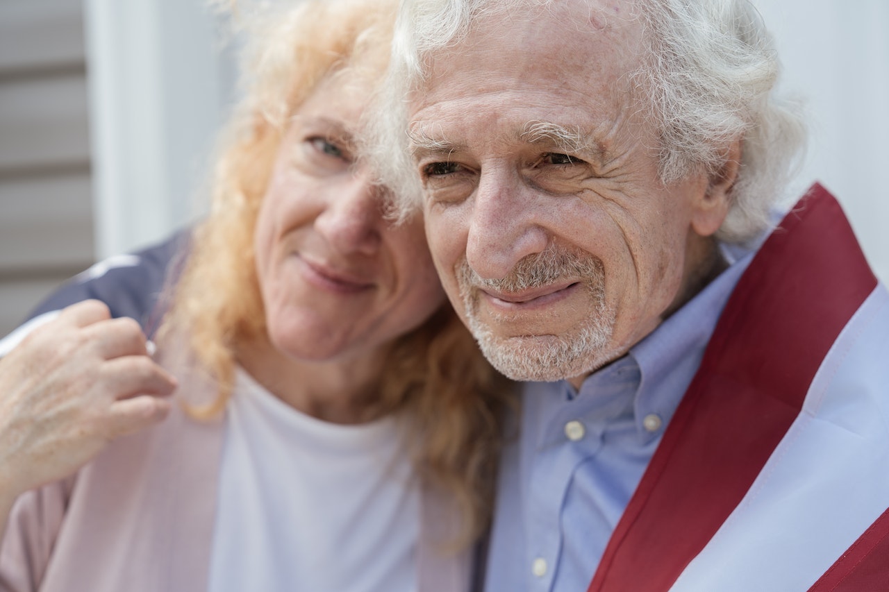 A Couple Draped with the American Flag | Veteran Car Donations
