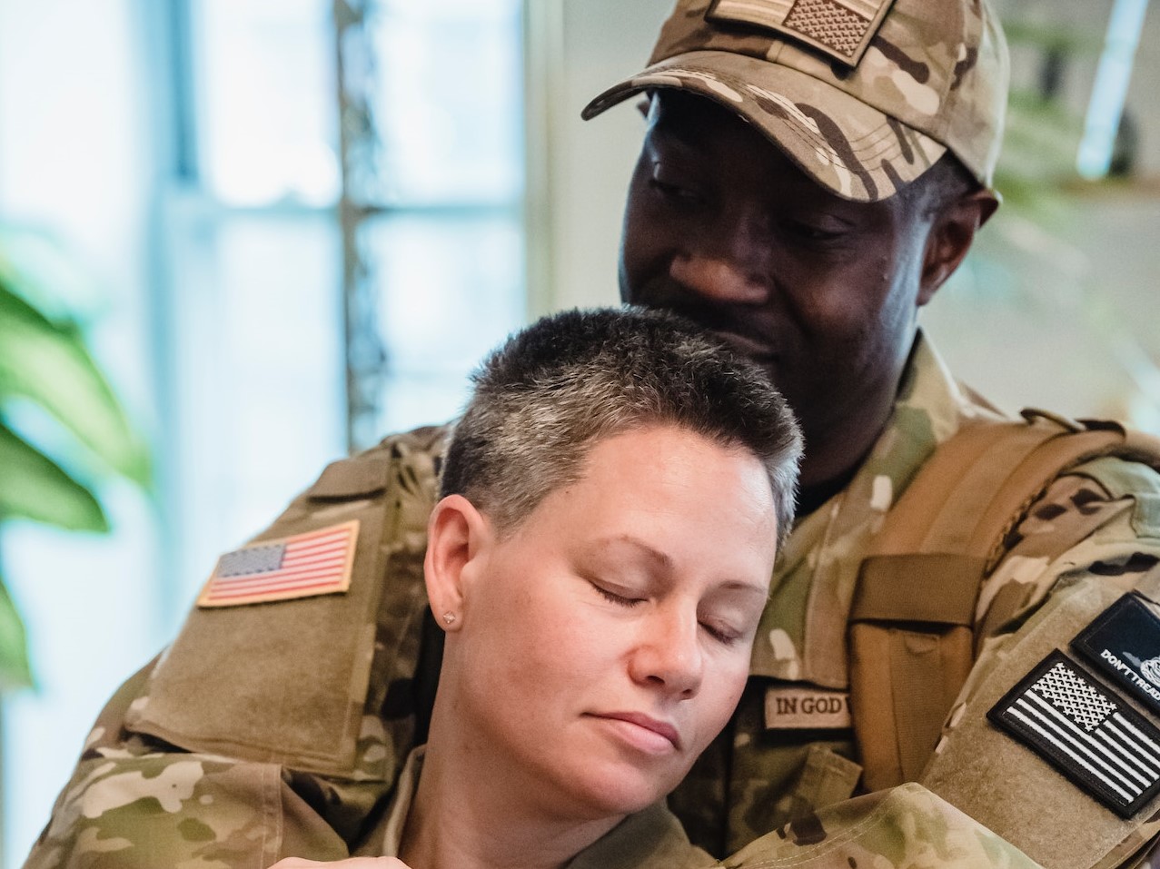 Man in Green and Brown Camouflage Uniform Hugging a Woman | Veteran Car Donations